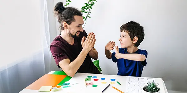 Happy autism boy during therapy with therapist